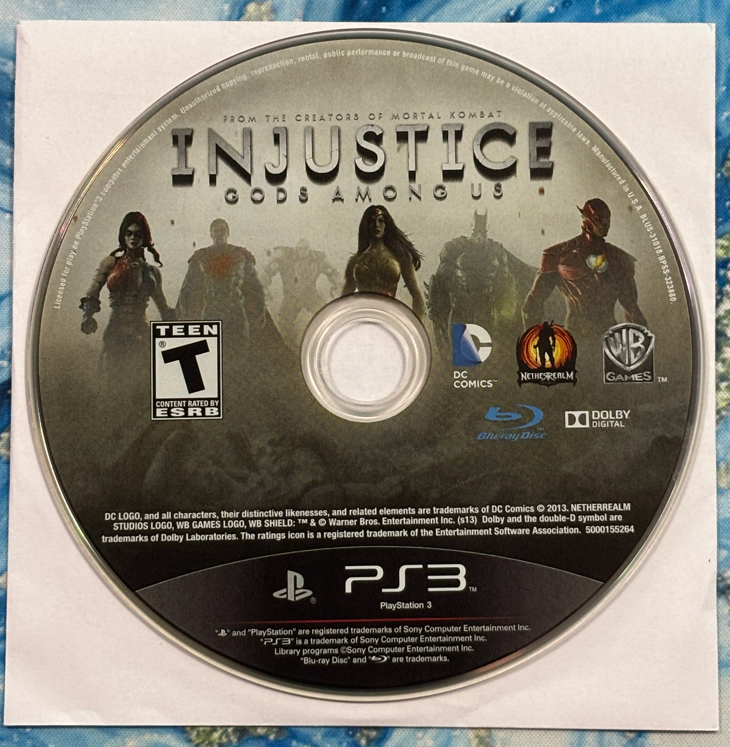 Game disc for 'Injustice: Gods Among Us' on a PlayStation 3 console.