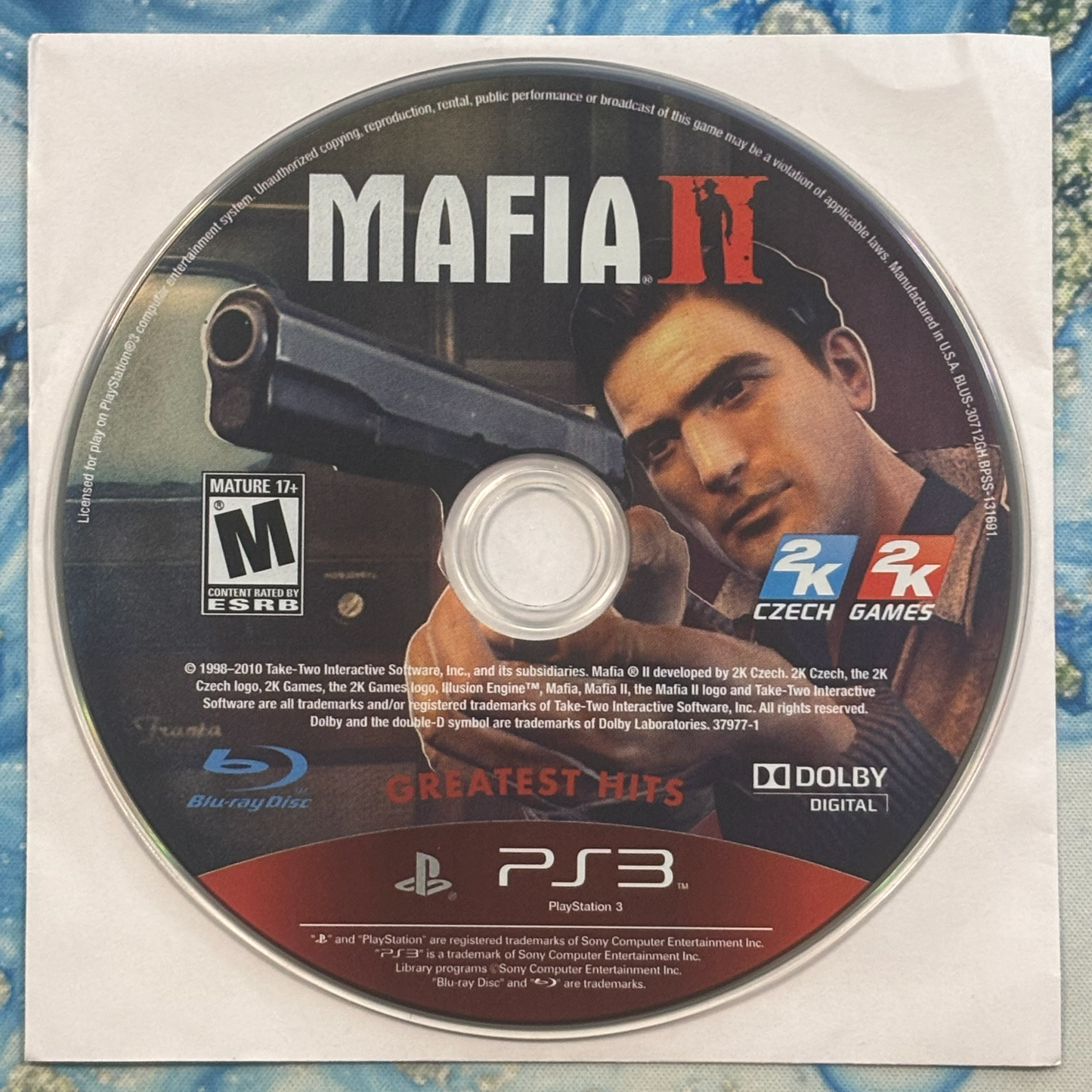 Mafia II game disc with 2K branding on a blue textured background