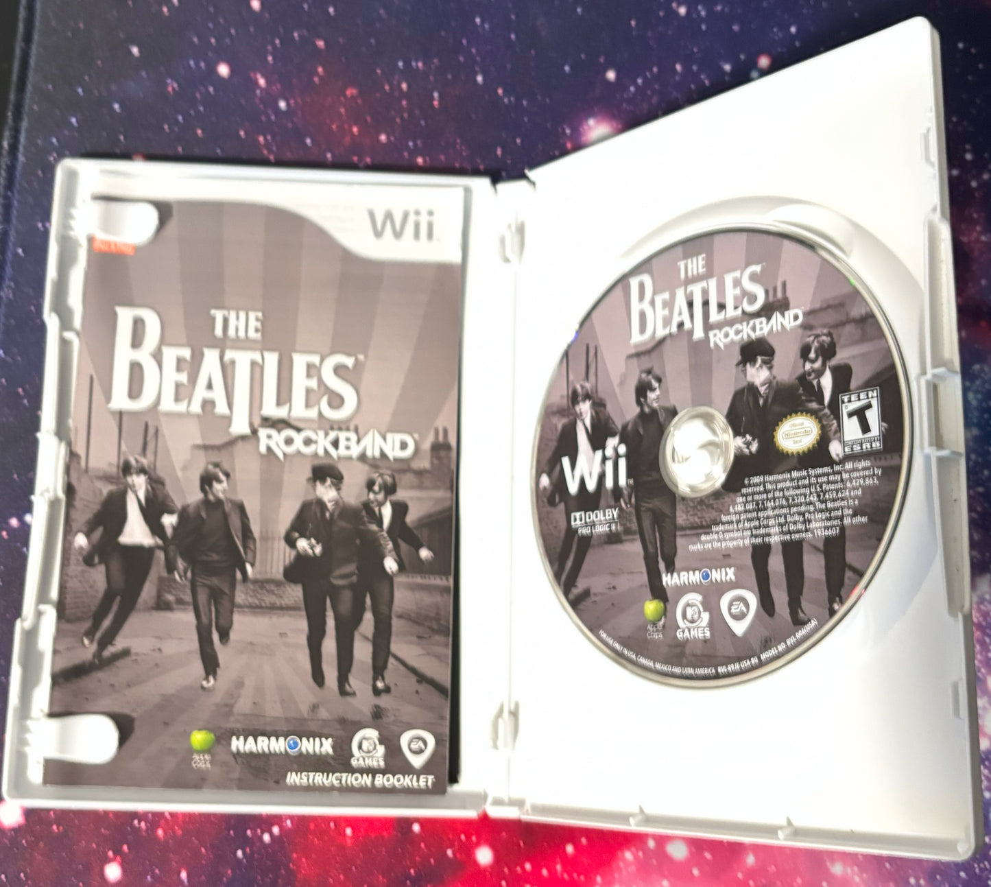 The Beatles Rock Band game case and disc for Wii console on a starry background