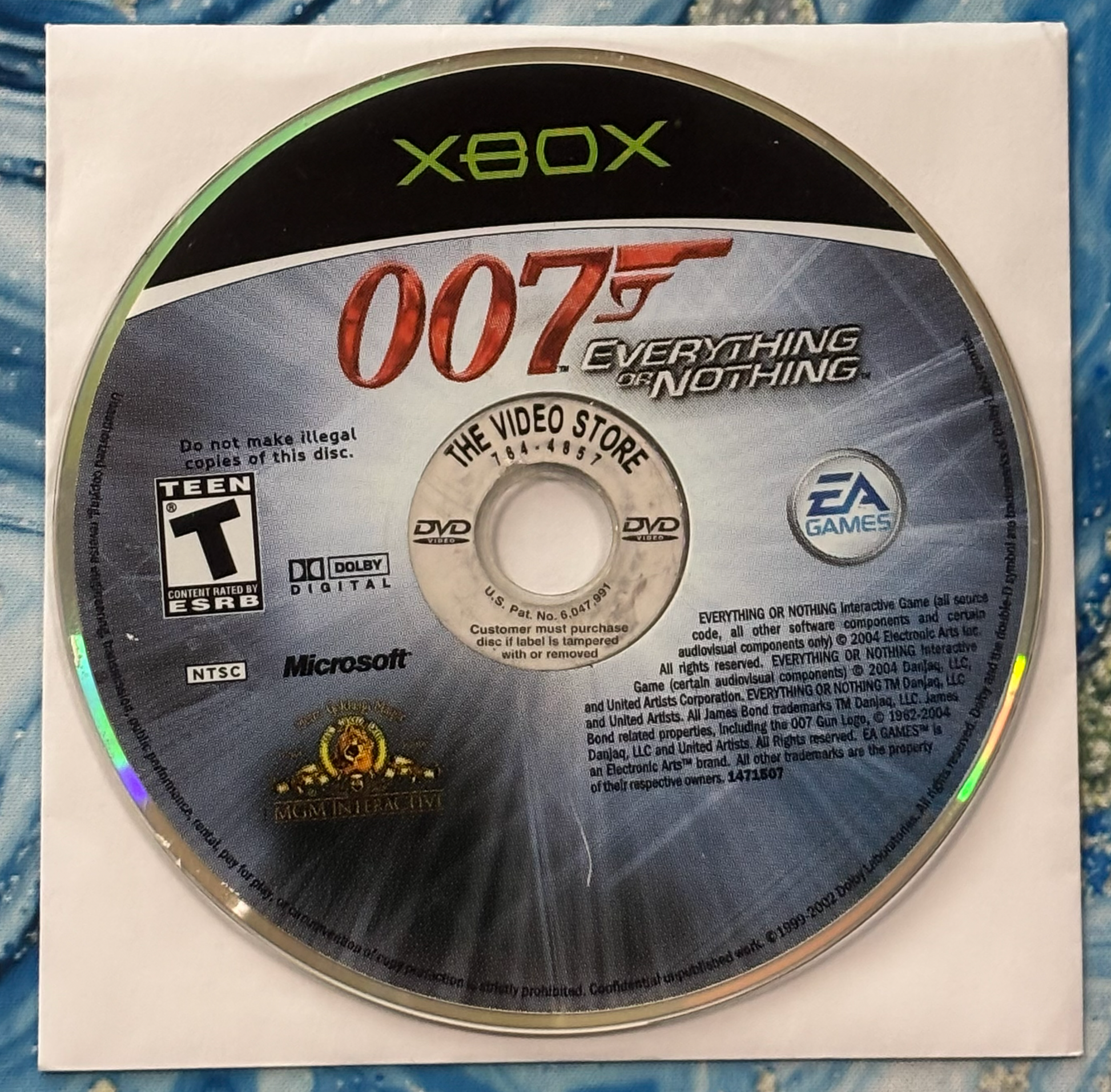 Xbox game disc for '007 Everything or Nothing' on a textured surface