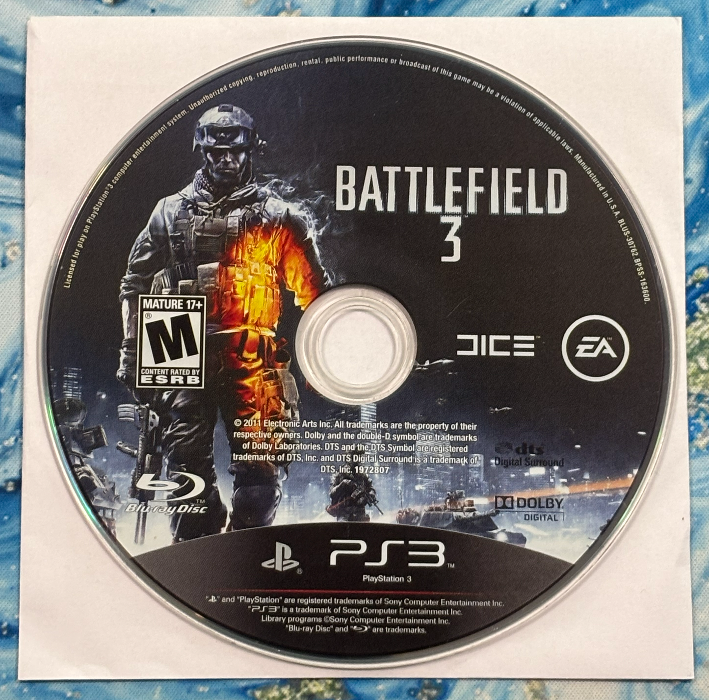 Game disc for 'Battlefield 3' on a PlayStation 3 console, featuring graphics and branding.