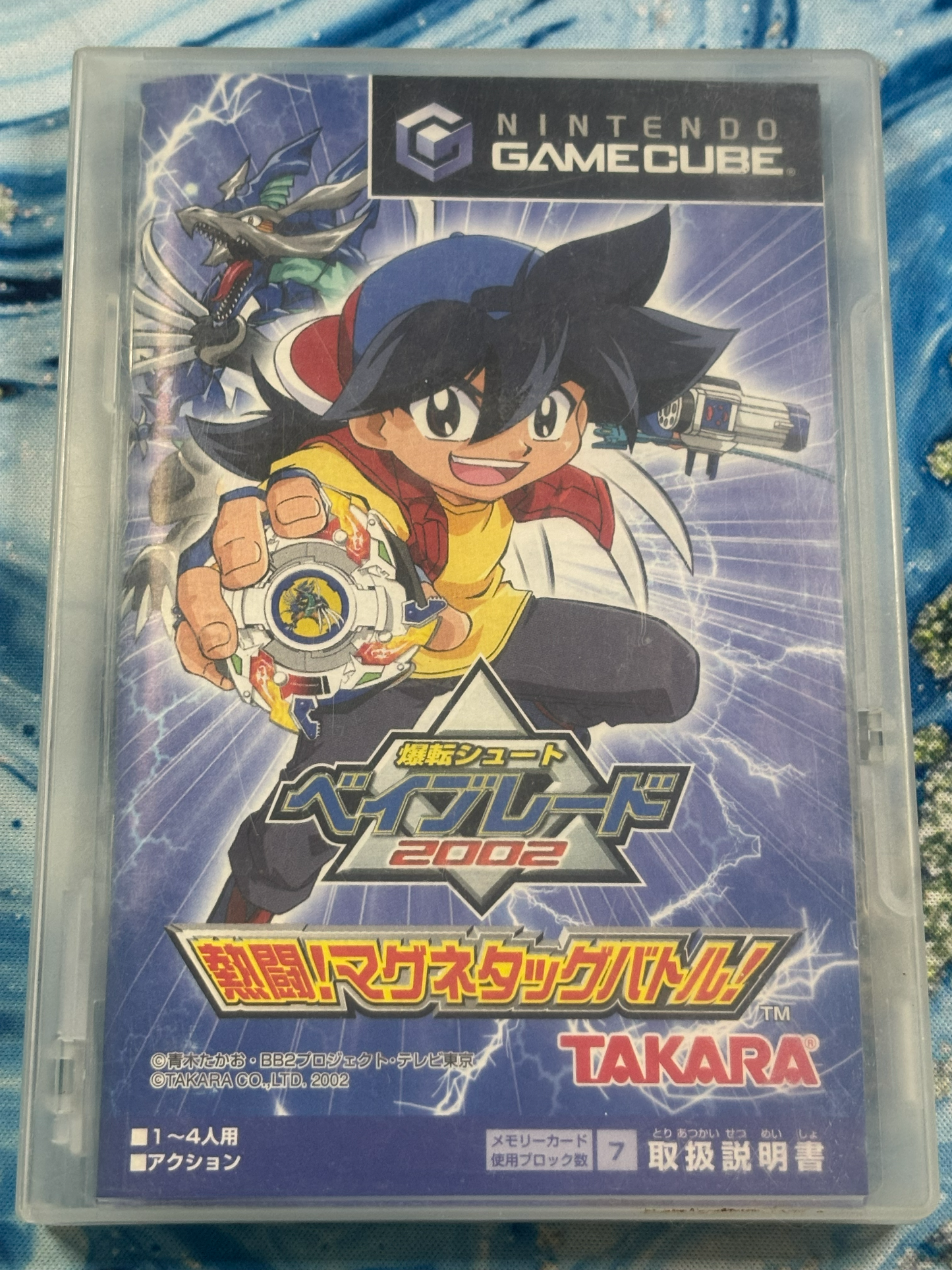 Nintendo GameCube toy guide case for Beyblade 2002, featuring Takara branding and anime character artwork on a blue textured background.