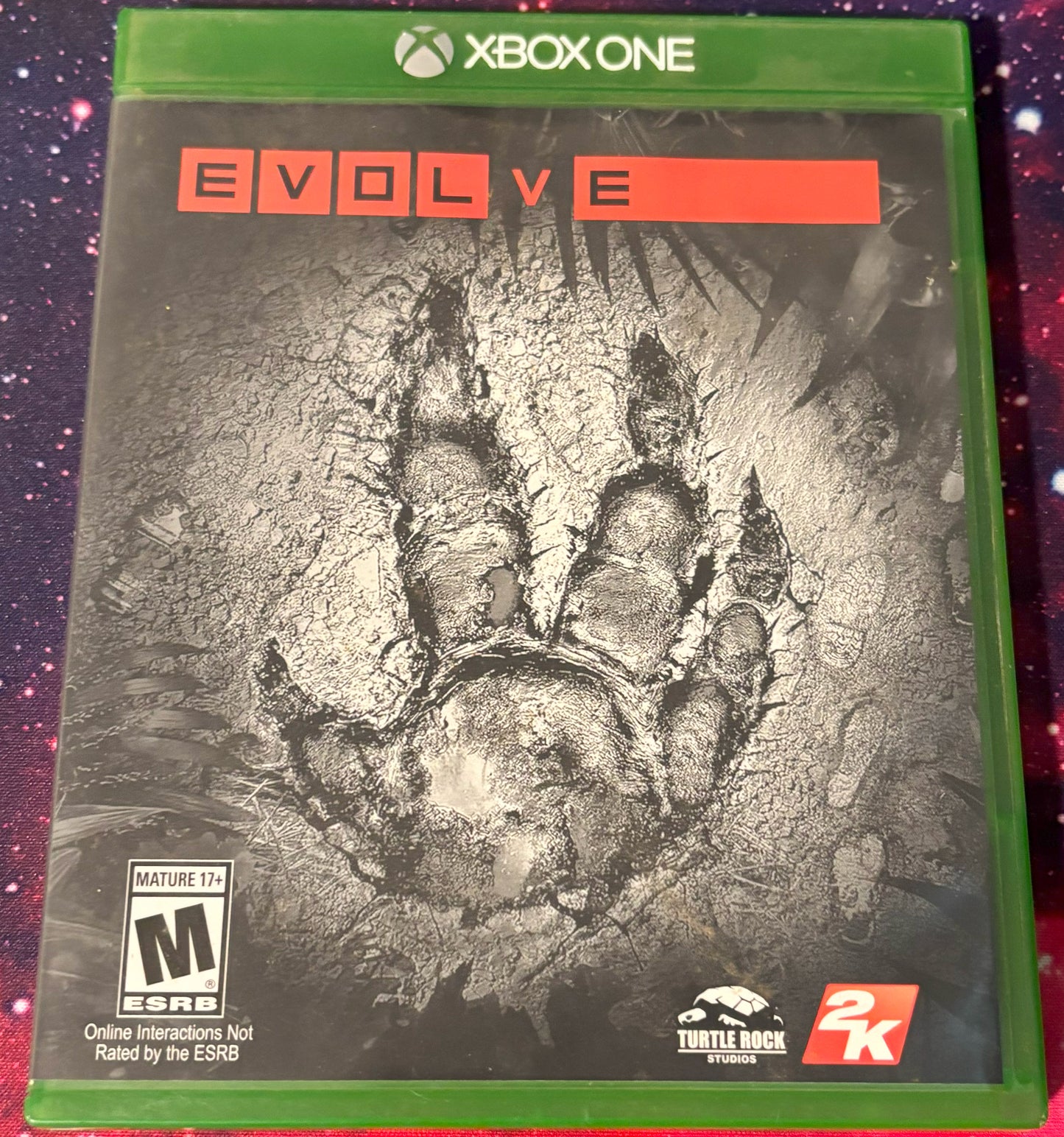 Game case for 'Evolve' on Xbox One with a dinosaur footprint design.