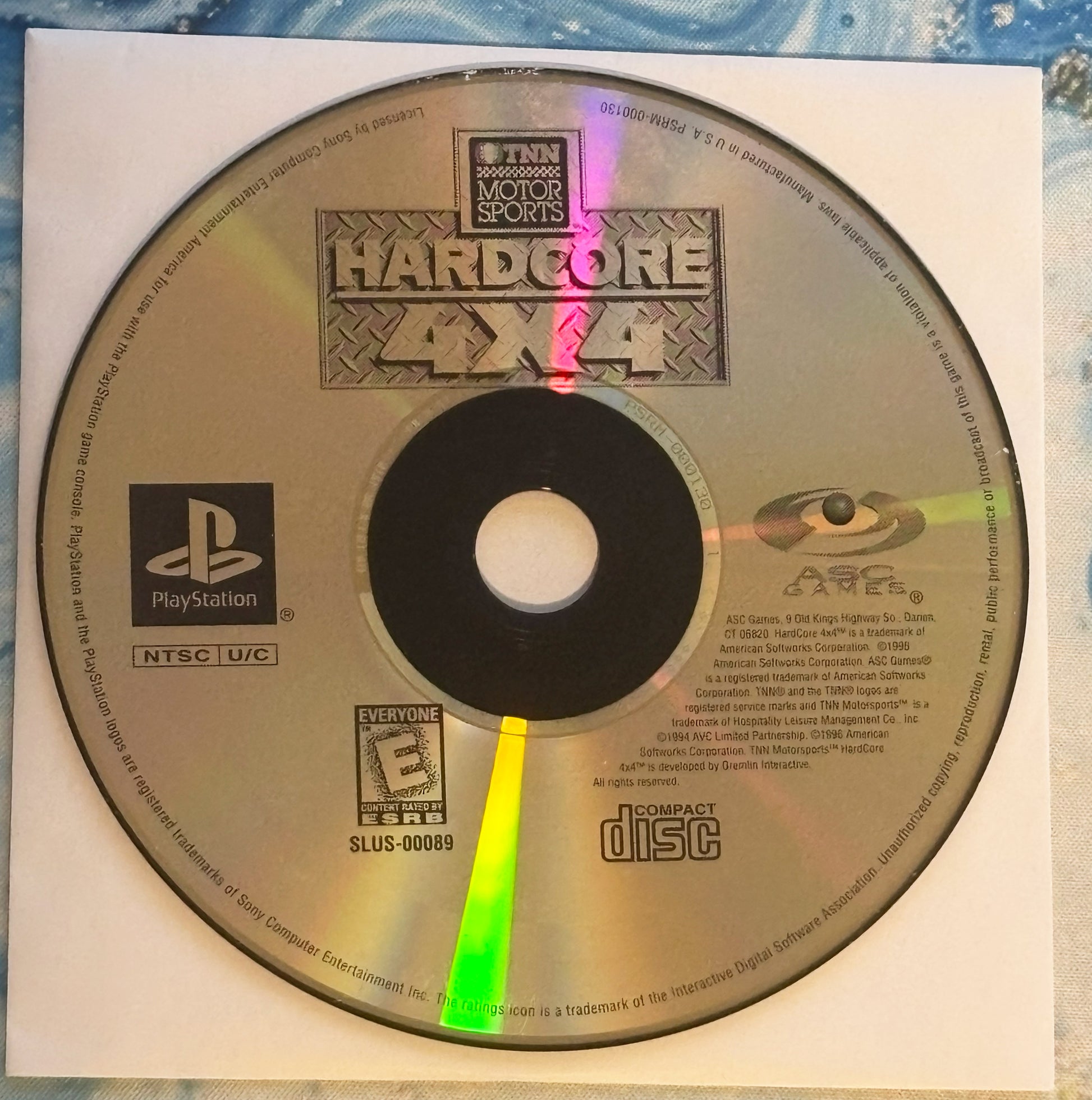 CD with 'Hardcore 4x4' PlayStation game cover on a textured surface