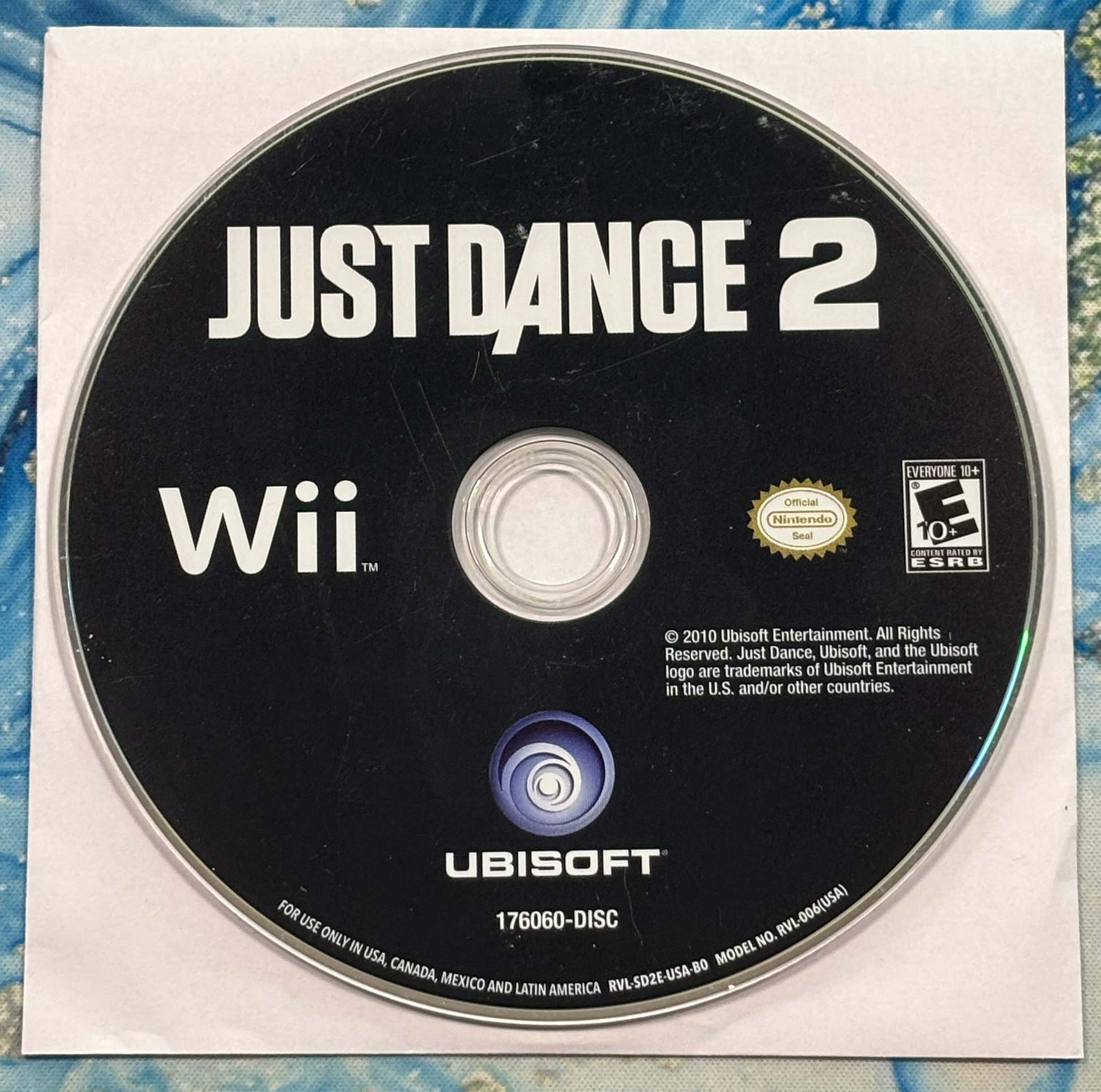 Just Dance 2 Wii game disc on a textured surface