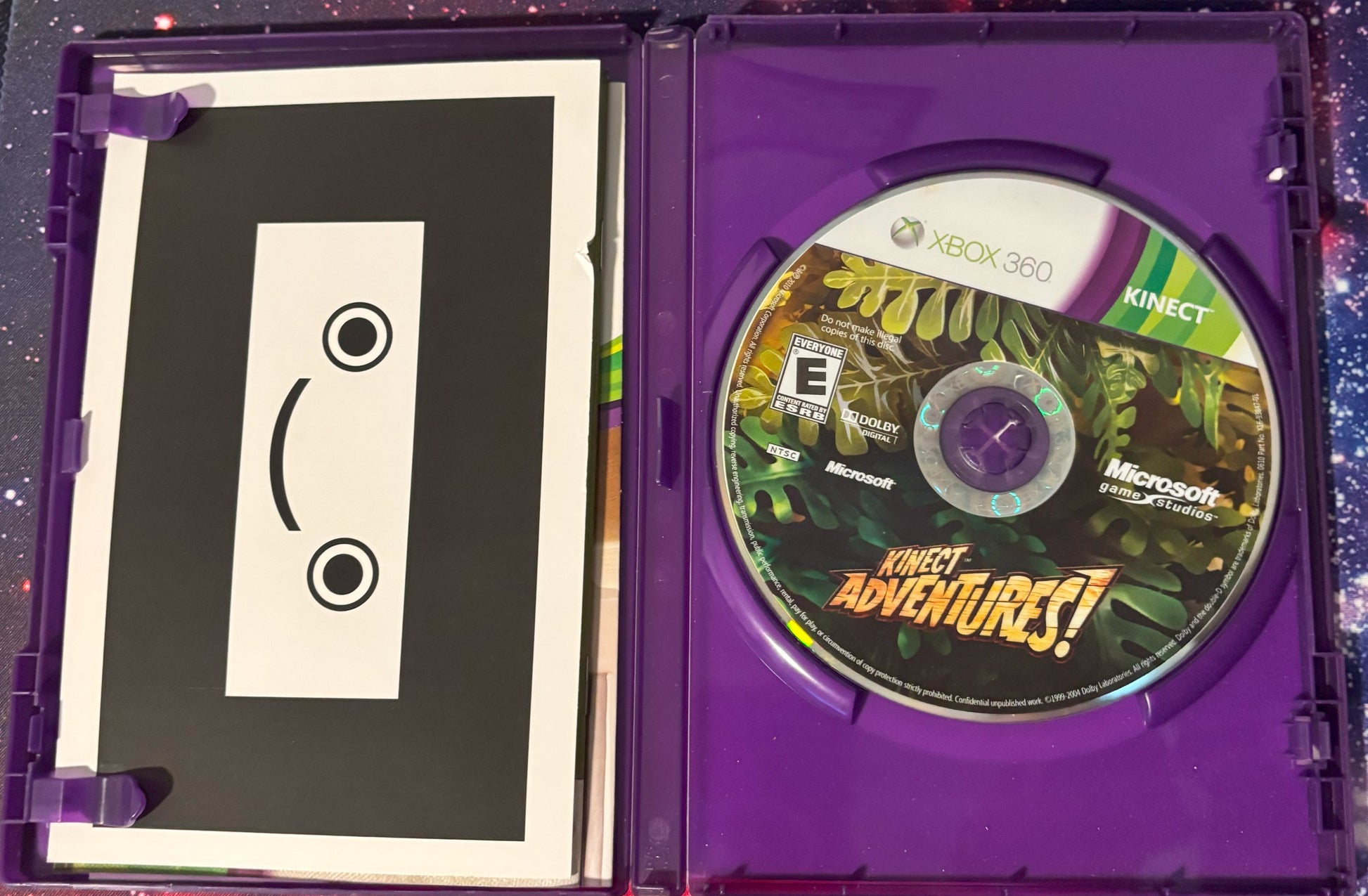 Xbox 360 Kinect Adventures game disc in a purple case with a cassette tape design.