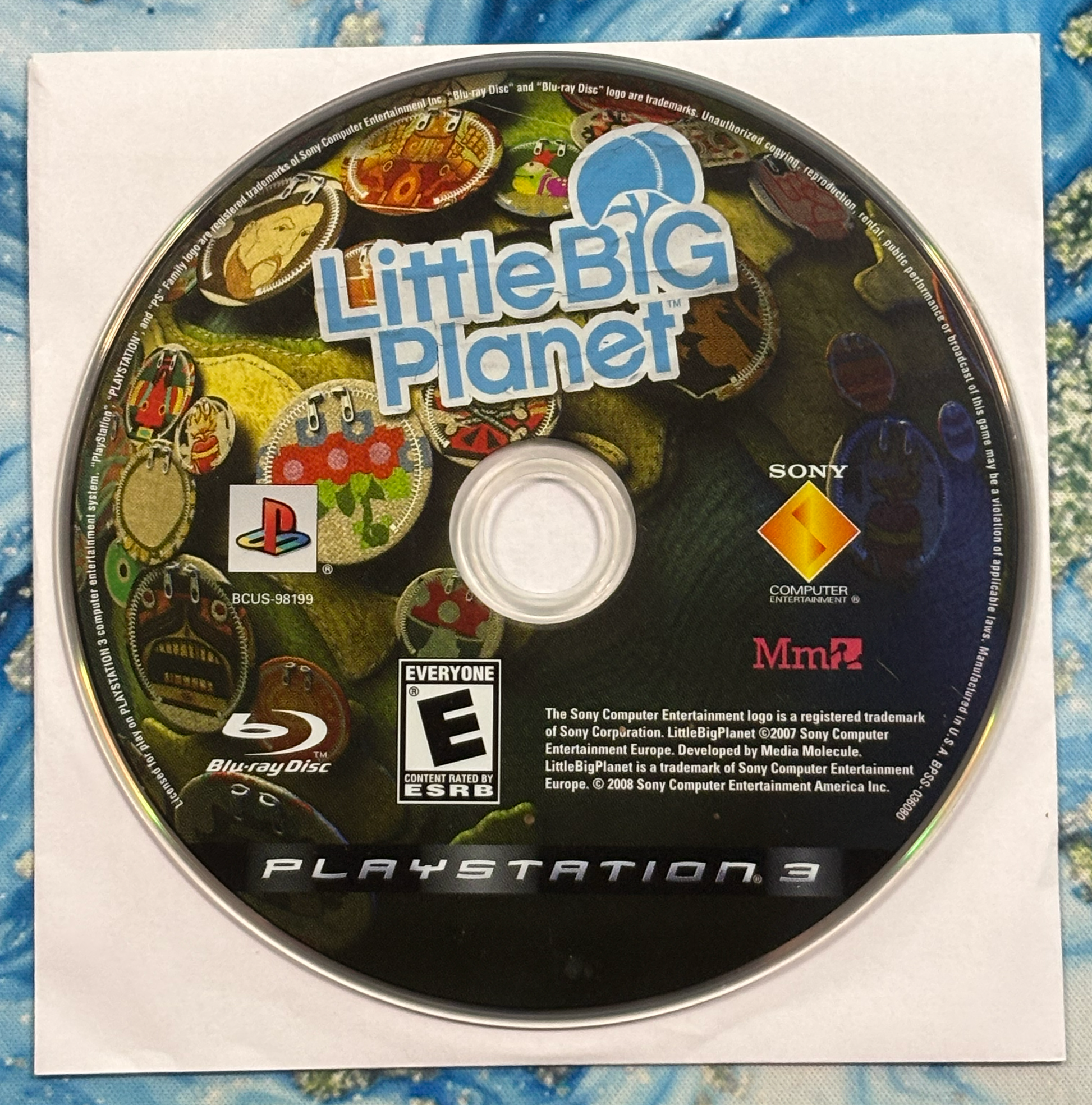 PlayStation 3 game disc for 'LittleBigPlanet' with branding and logos.
