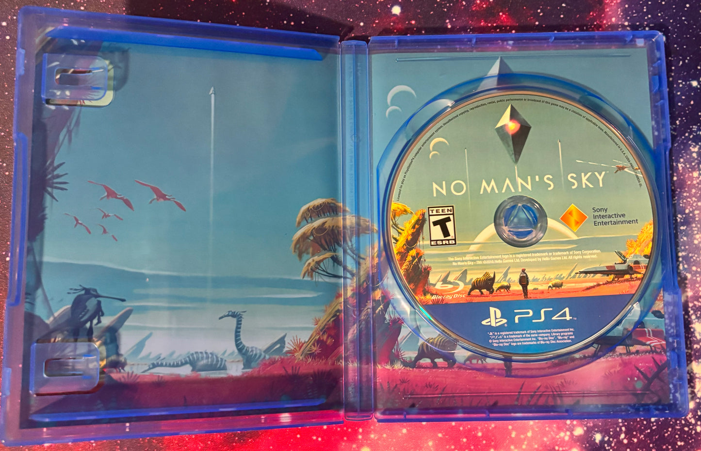 No Man's Sky game disc and cover on a glittery purple surface