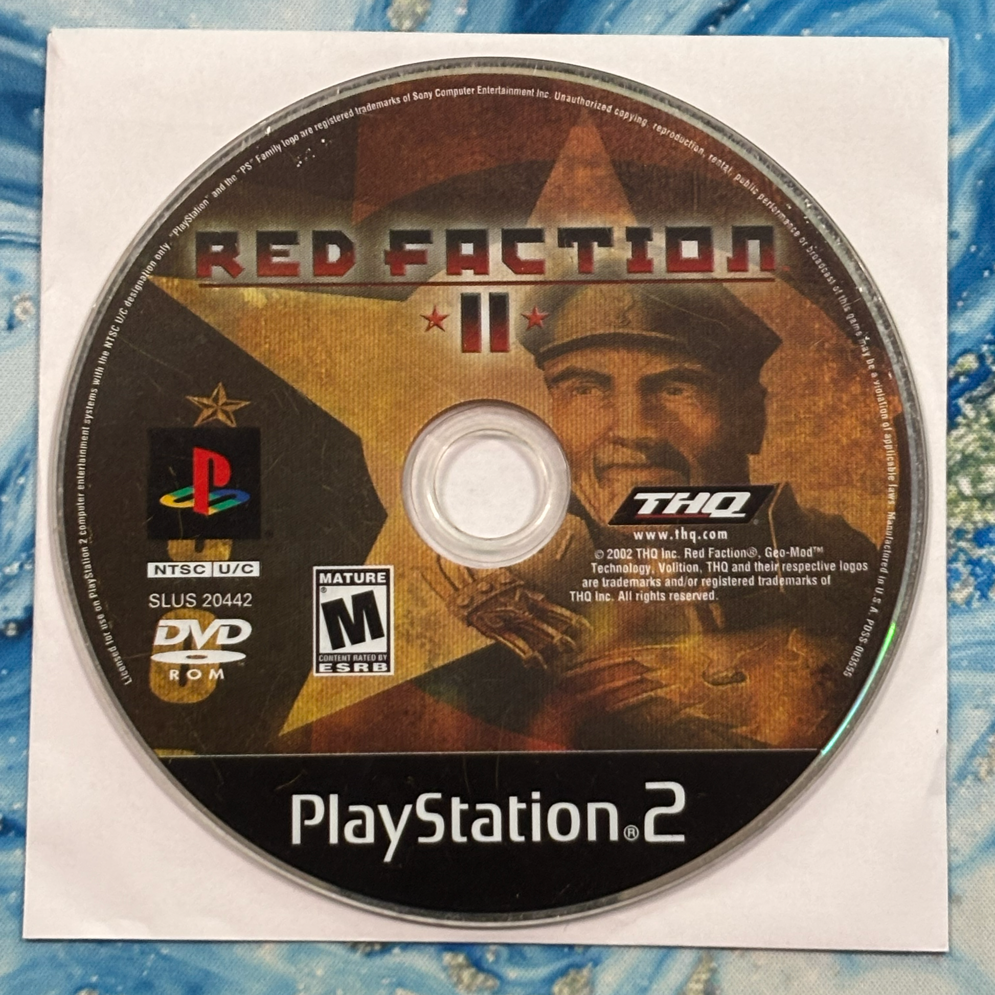 PlayStation 2 game disc for 'Red Faction II' with THQ and PlayStation logos.