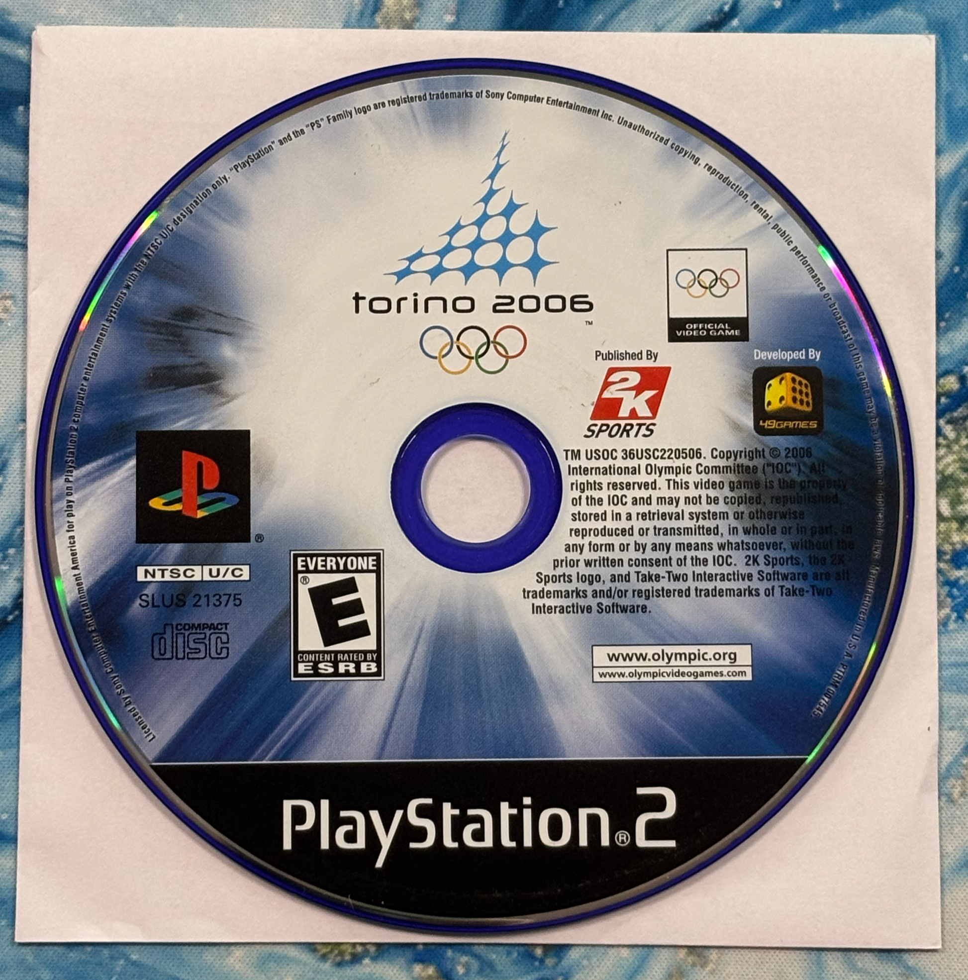 PlayStation 2 game disc for 'Torino 2006' Olympics on a textured surface