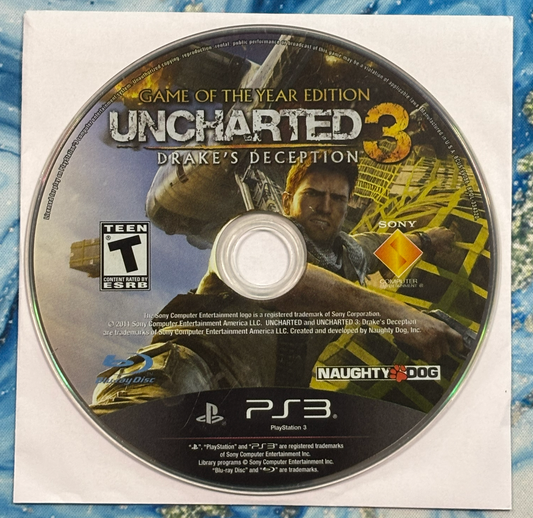 Game disc for 'Uncharted 3: Drake's Deception' with PlayStation 3 logo on a textured surface